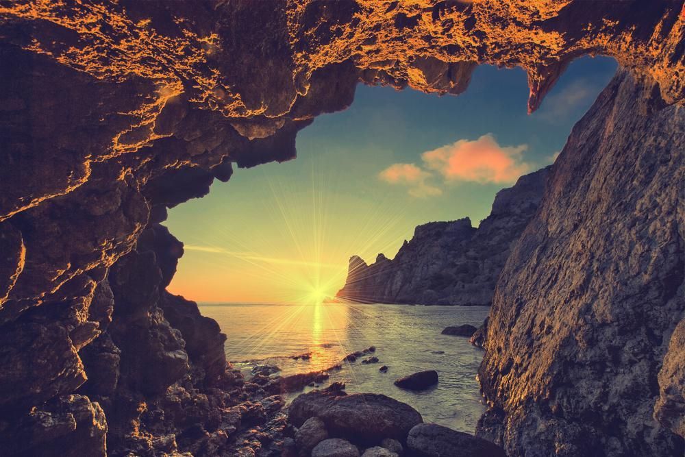 The Sun is Setting Over the Ocean From a Cave — Angel of Light Nick Turner In Byron Bay, NSW