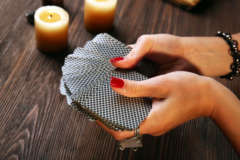 A Woman is Holding a Stack of Playing Cards in Her Hands — Angel of Light Nick Turner In East Lismore, NSW