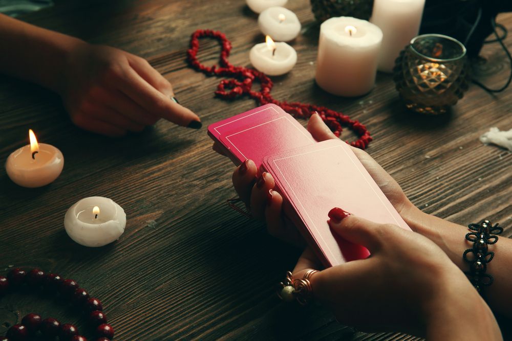 A Woman is Holding a Pink Tarot Card in Her Hands — Angel of Light Nick Turner In Gold Coast, NSW