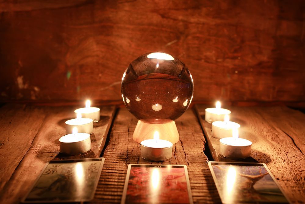 A Crystal Ball Surrounded by Candles and Tarot Cards on a Wooden Table — Angel of Light Nick Turner In East Lismore, NSW