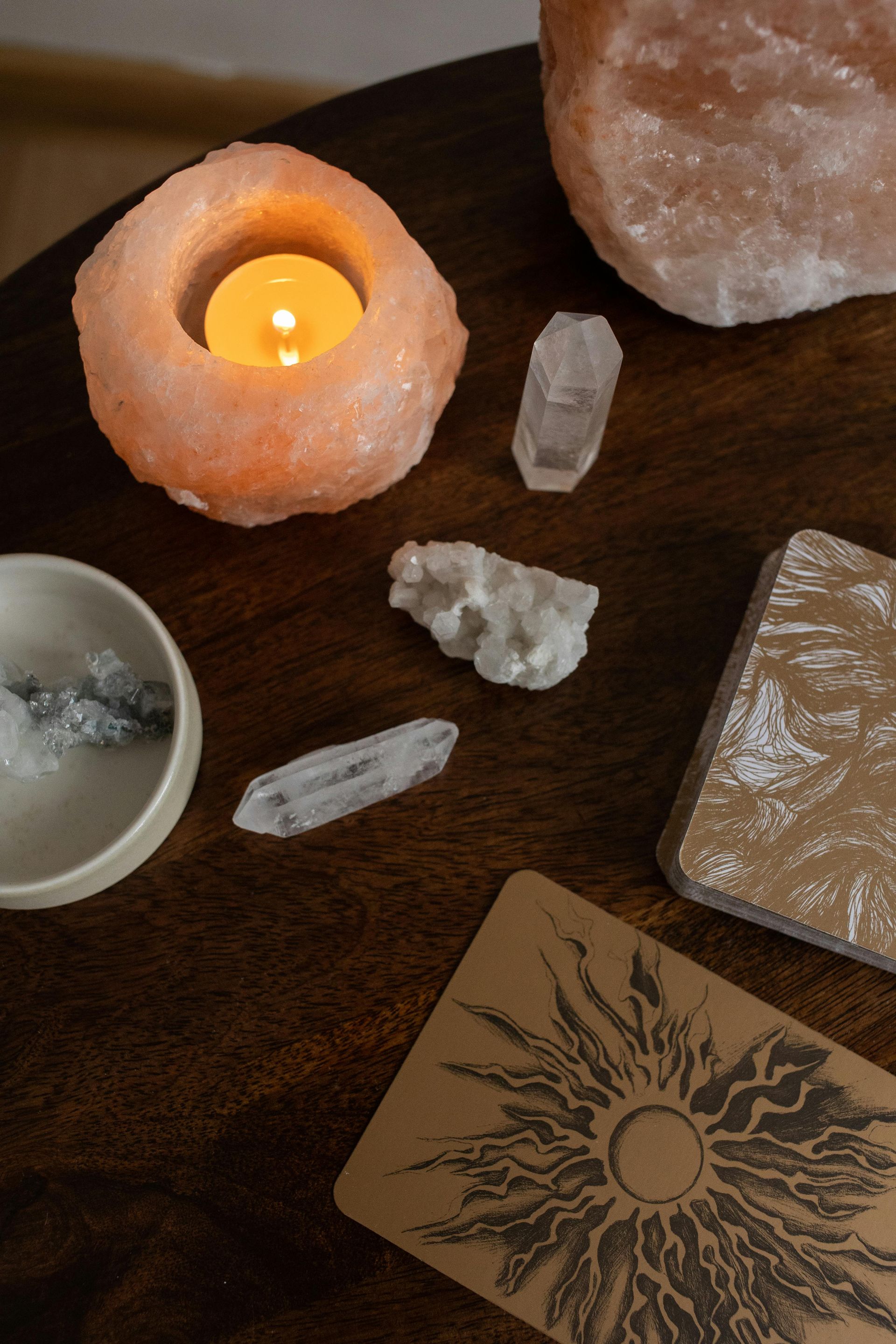 A Wooden Table Topped With Candles, Crystals, and a Tarot Card