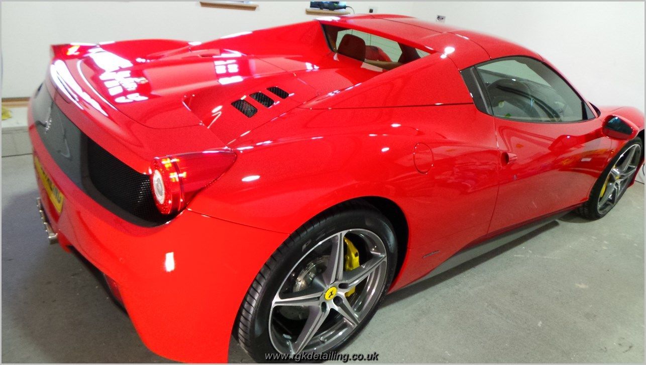 A red ferrari sports car is parked in a garage