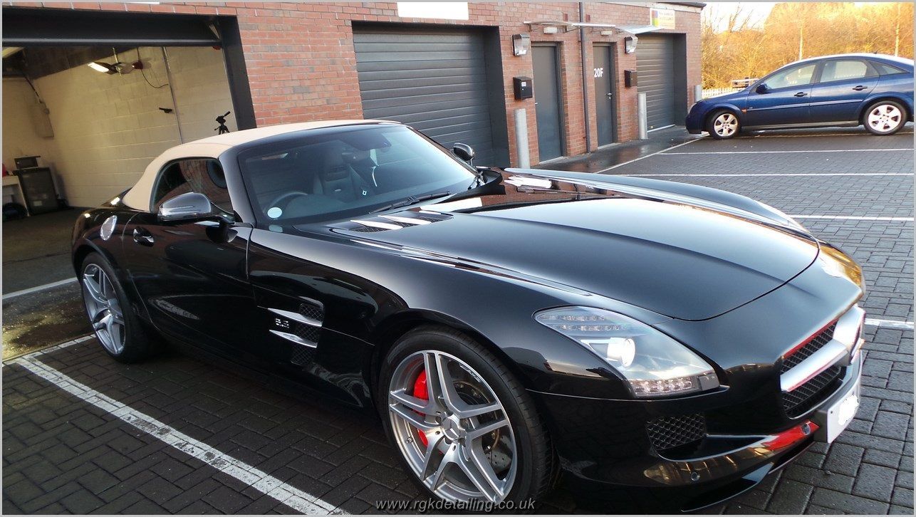 A black sports car is parked in a parking lot