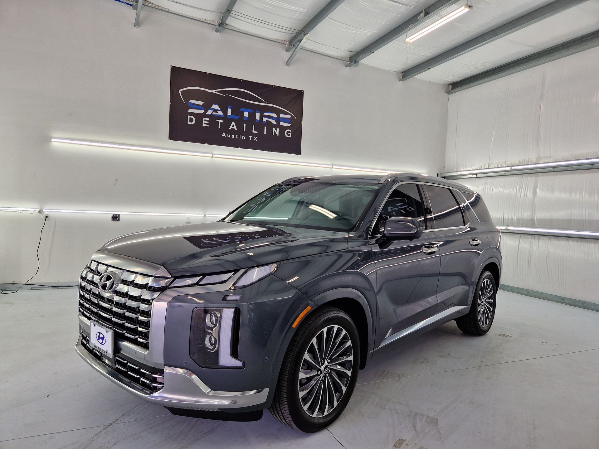 A gray hyundai palisade is parked in a car wash.