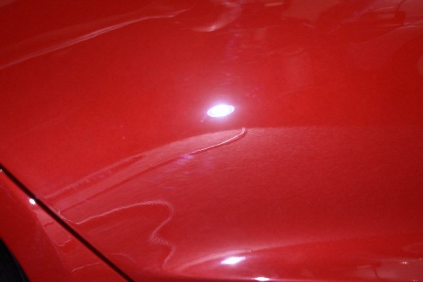 A close up of the hood of a red car