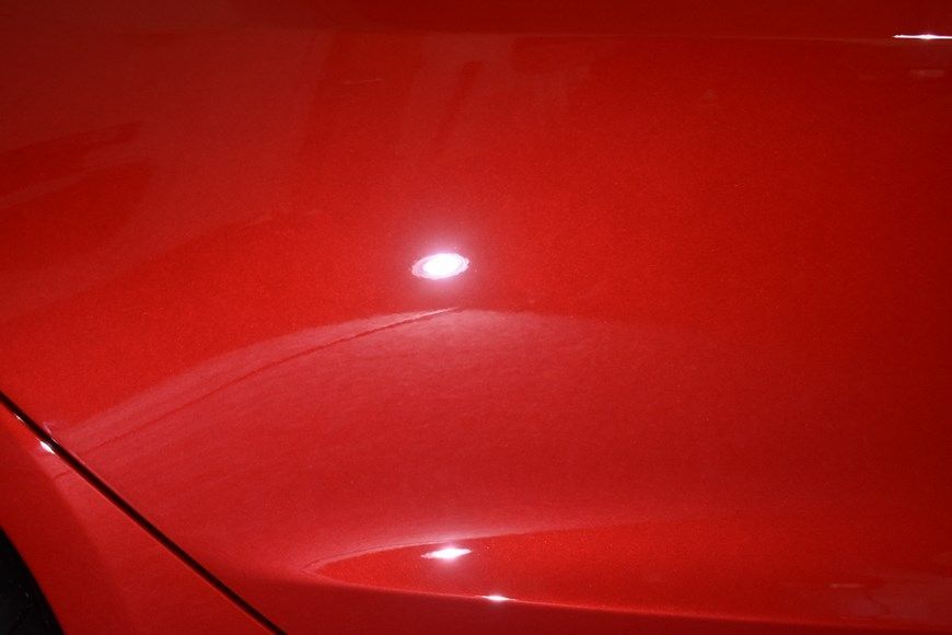 A close up of the hood of a red car