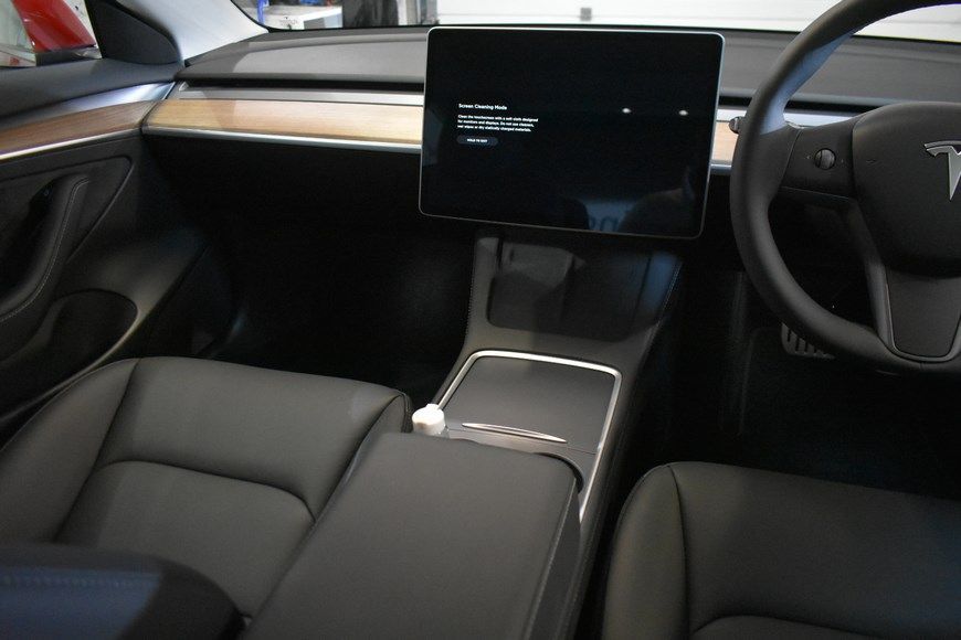 The interior of a tesla model 3 with a large screen on the dashboard.