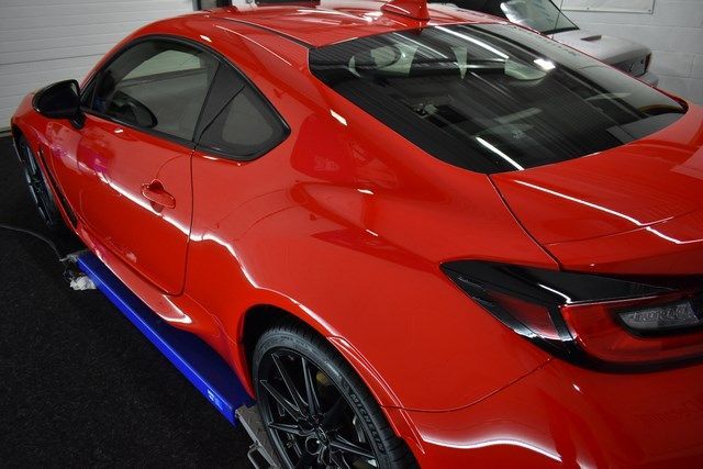 A red sports car is parked in a garage.