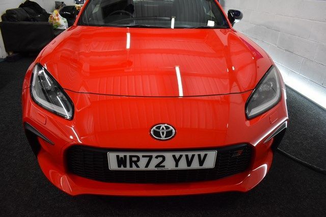 A red sports car with a license plate that says wr72 yvv