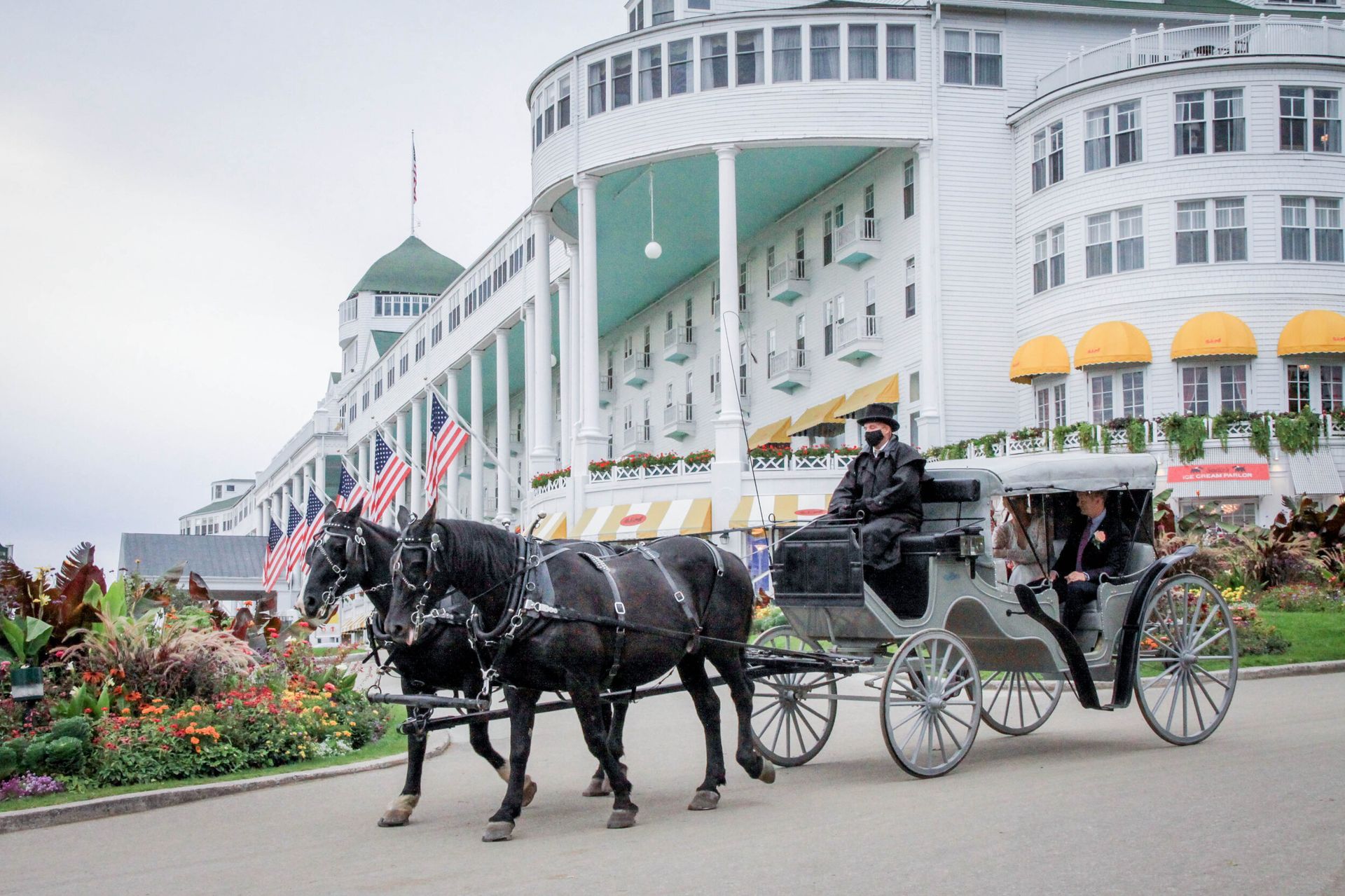 a horse drawn carriage is driving down the street in front of a large building .