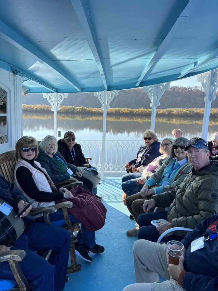 a group of people are sitting on a boat looking at the water .