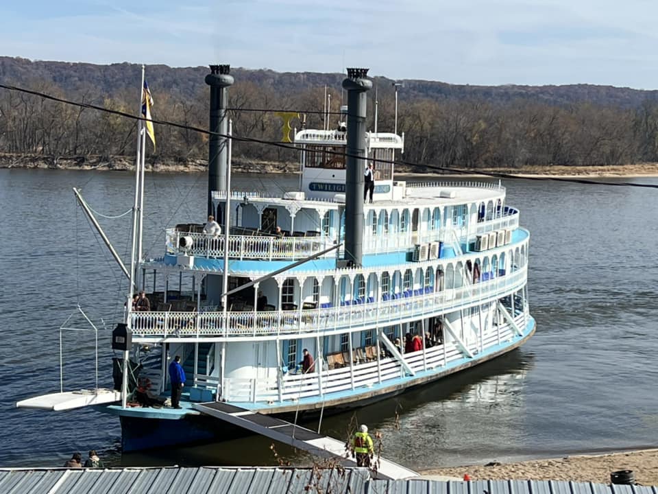 a large boat is docked at a dock on a river .