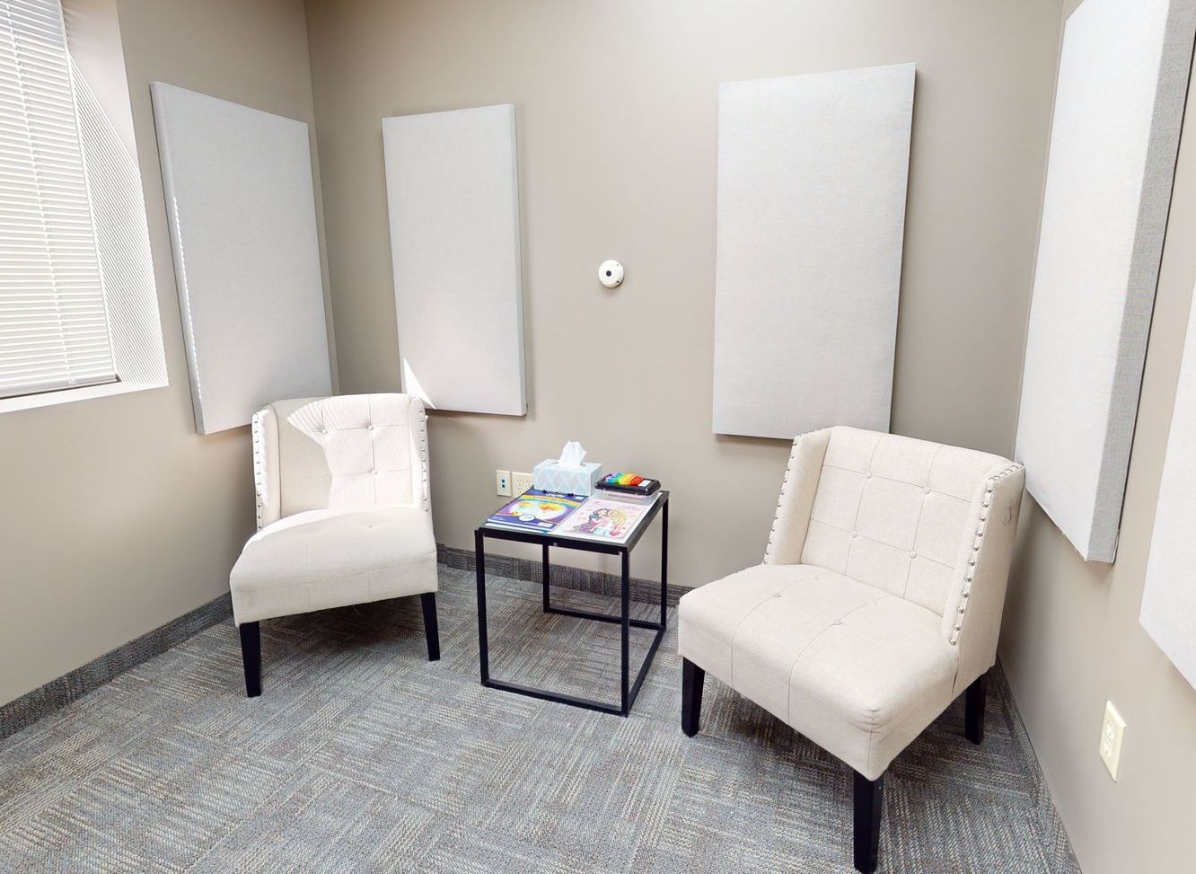 There are two chairs and a table in the room.