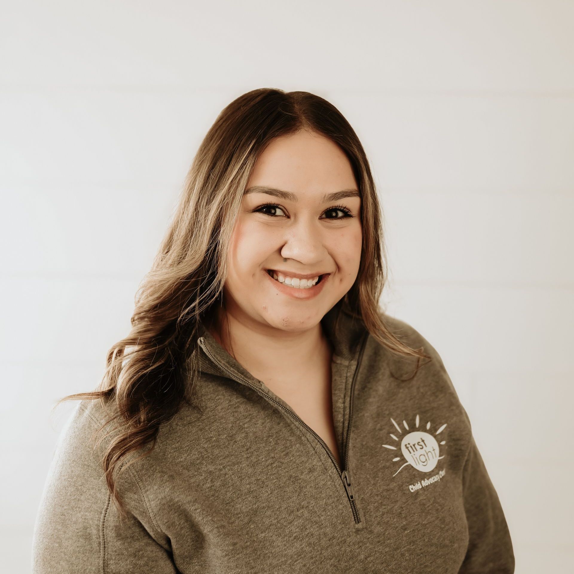 A woman wearing a black shirt with the word support on it is smiling.