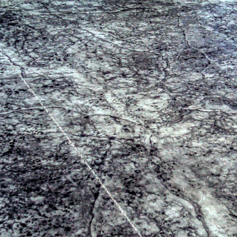 A close up of a gray and white marble floor