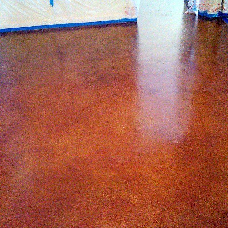 A close up of a stained concrete floor in a room.