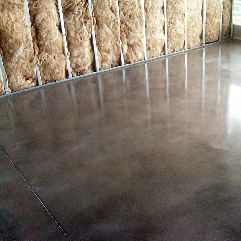 A room with a concrete floor and a wall with insulation