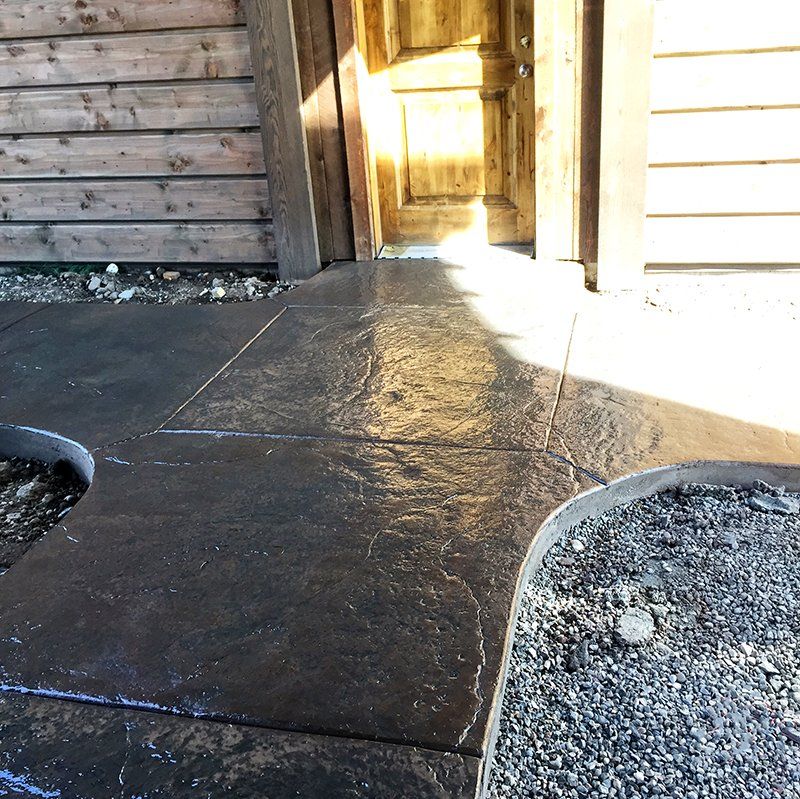 A concrete walkway in front of a wooden building