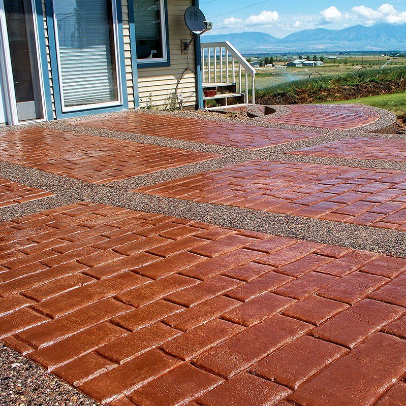 A brick walkway leading to a house with mountains in the background