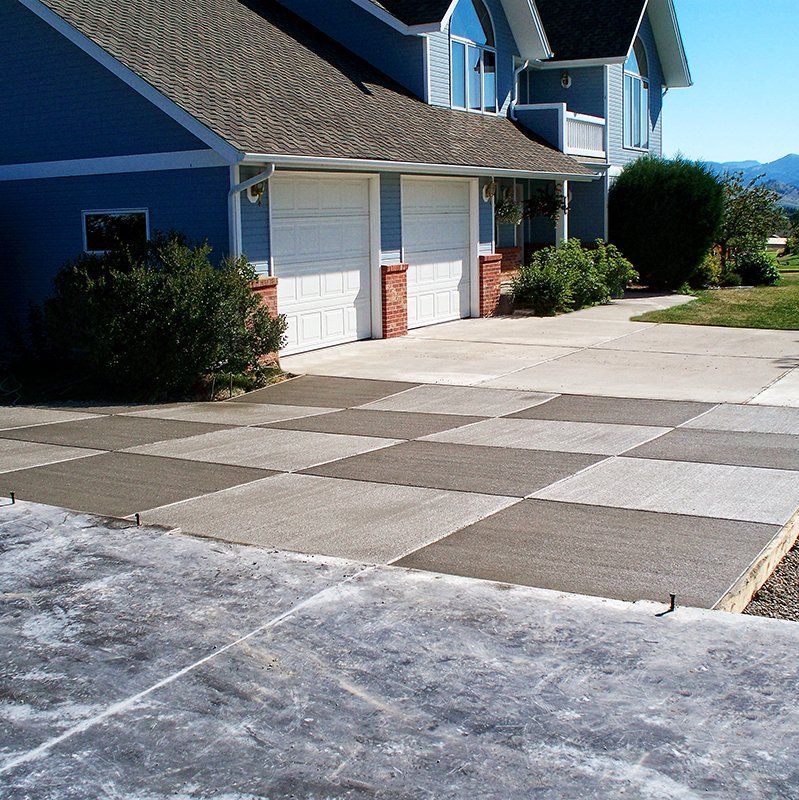 A blue house with a checkered driveway in front of it