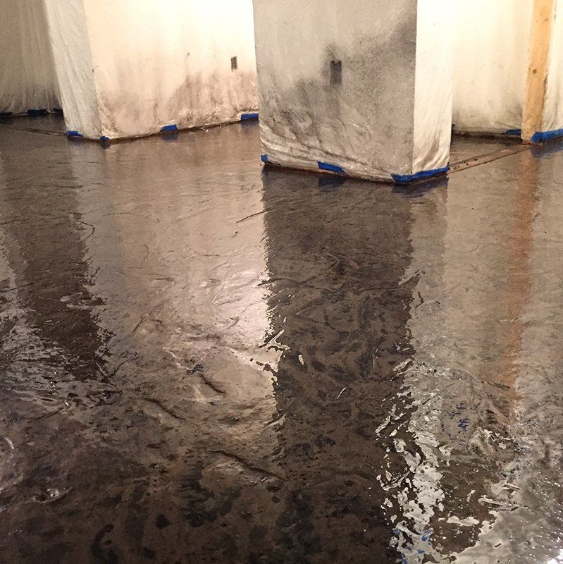 A wet floor with a reflection of a building in it