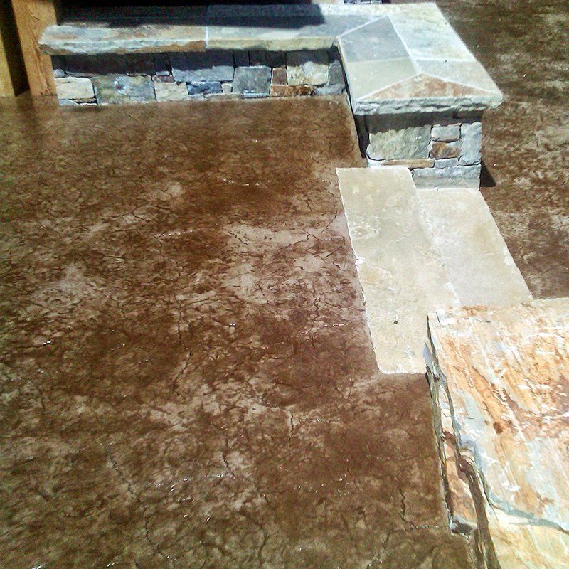 A concrete walkway with steps and a stone wall