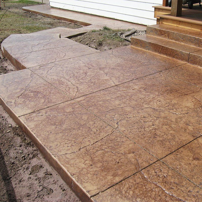 A concrete walkway with steps leading up to a house