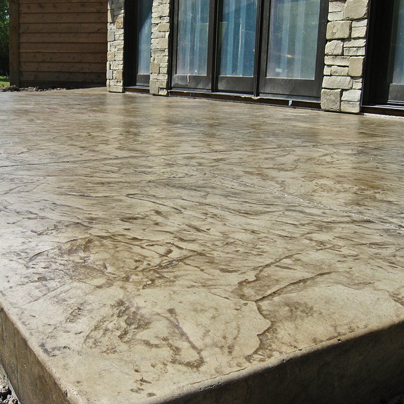 A patio with a stone wall and sliding glass doors