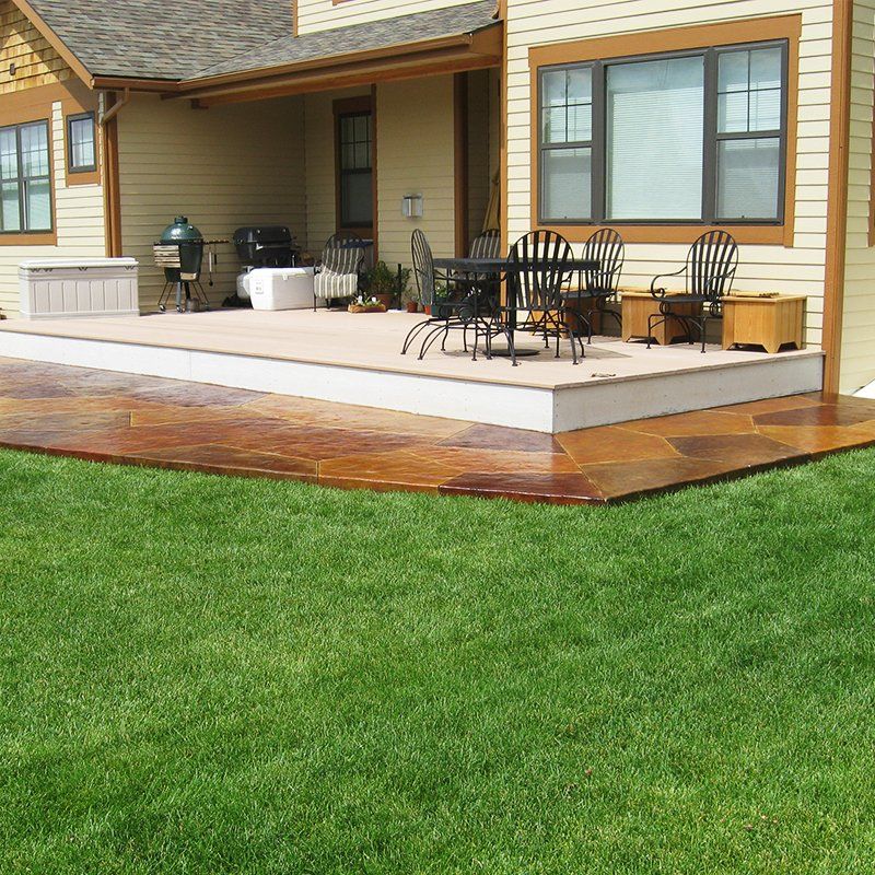 A patio with a table and chairs in front of a house