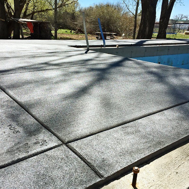 A concrete deck is being built next to a swimming pool