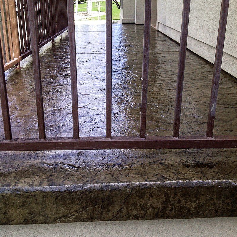 A concrete walkway with a metal railing and steps
