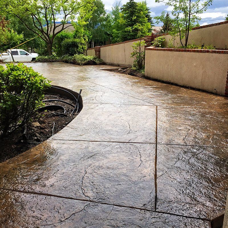 A concrete walkway with a car parked in the background