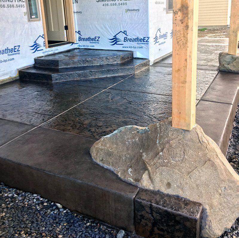 A concrete walkway with a wooden post in front of a building that says breatheez