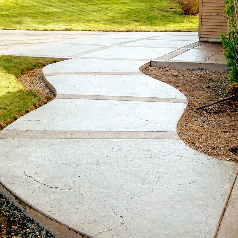 A curved concrete walkway leading to a house