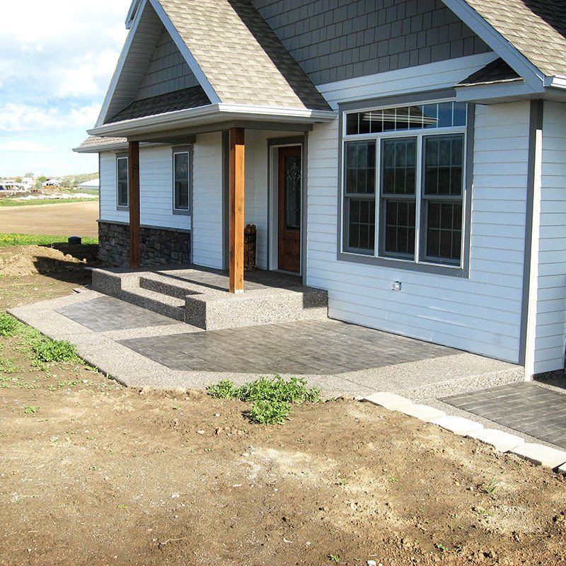 A white house with a gray roof and a porch
