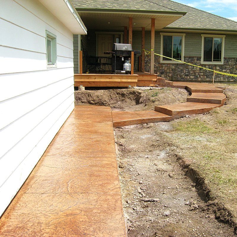 A white house with a concrete walkway leading to it