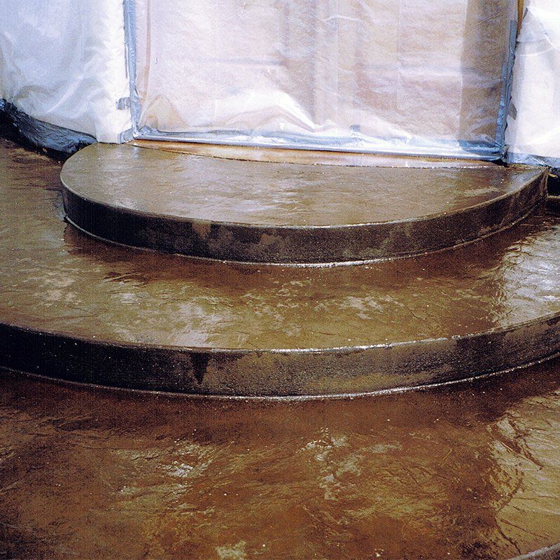 A set of concrete steps with a white tarp in the background