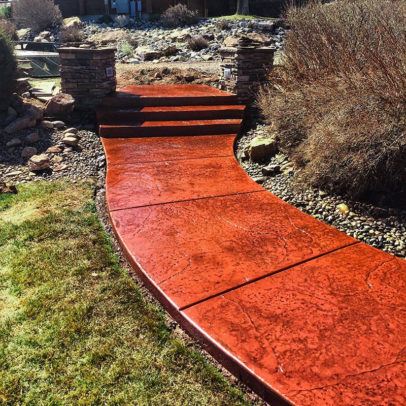 A red concrete walkway with stairs in the background