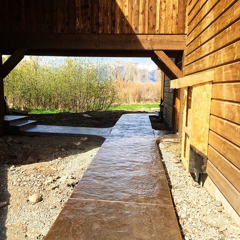 A concrete walkway leading to a wooden building