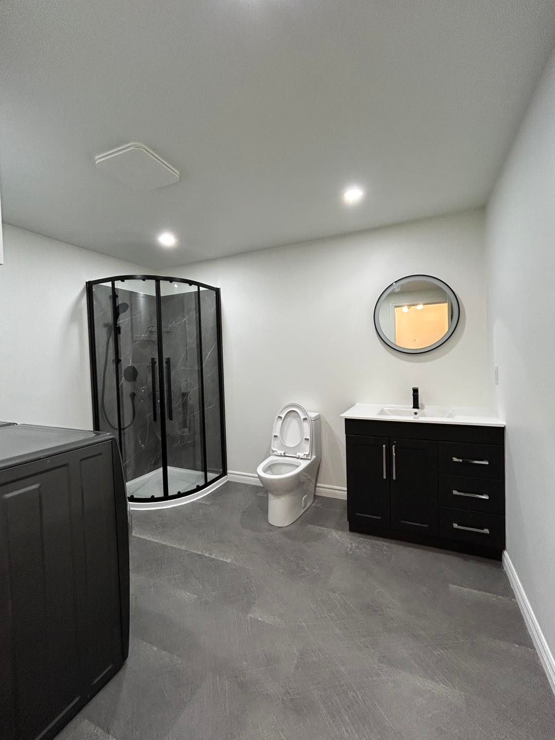 Une salle de bain avec WC, lavabo, douche et miroir.