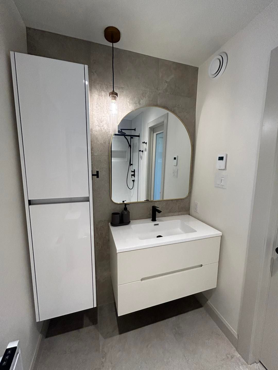 Une salle de bain avec lavabo, miroir et armoires.