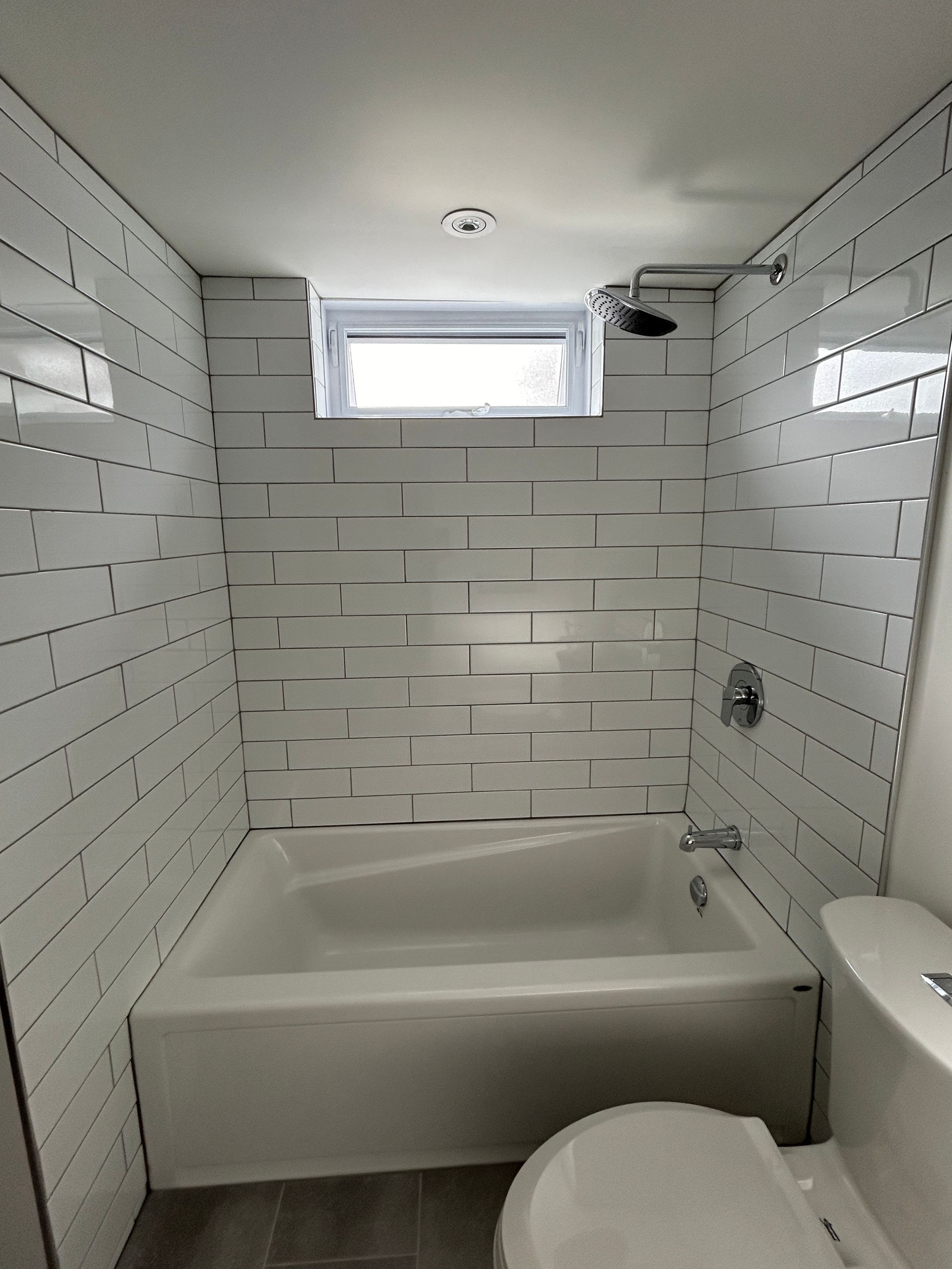 Une salle de bain avec baignoire, WC et douche.