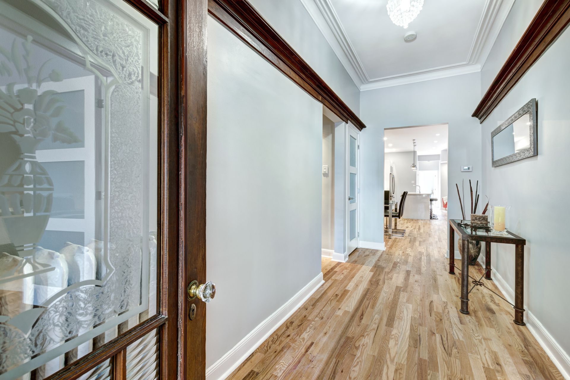 Un couloir avec parquet et porte vitrée