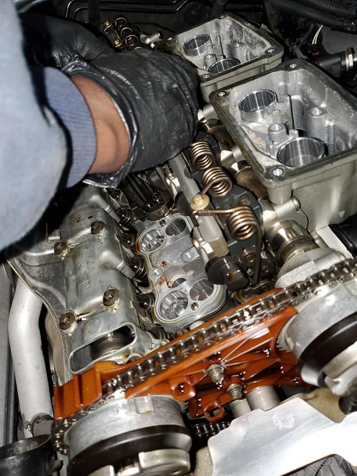 A person is working on the engine of a car