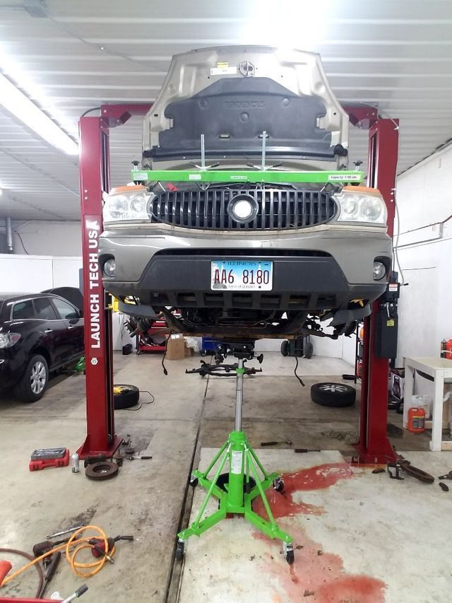 A car is sitting on a lift in a garage with a license plate that says a16 elise