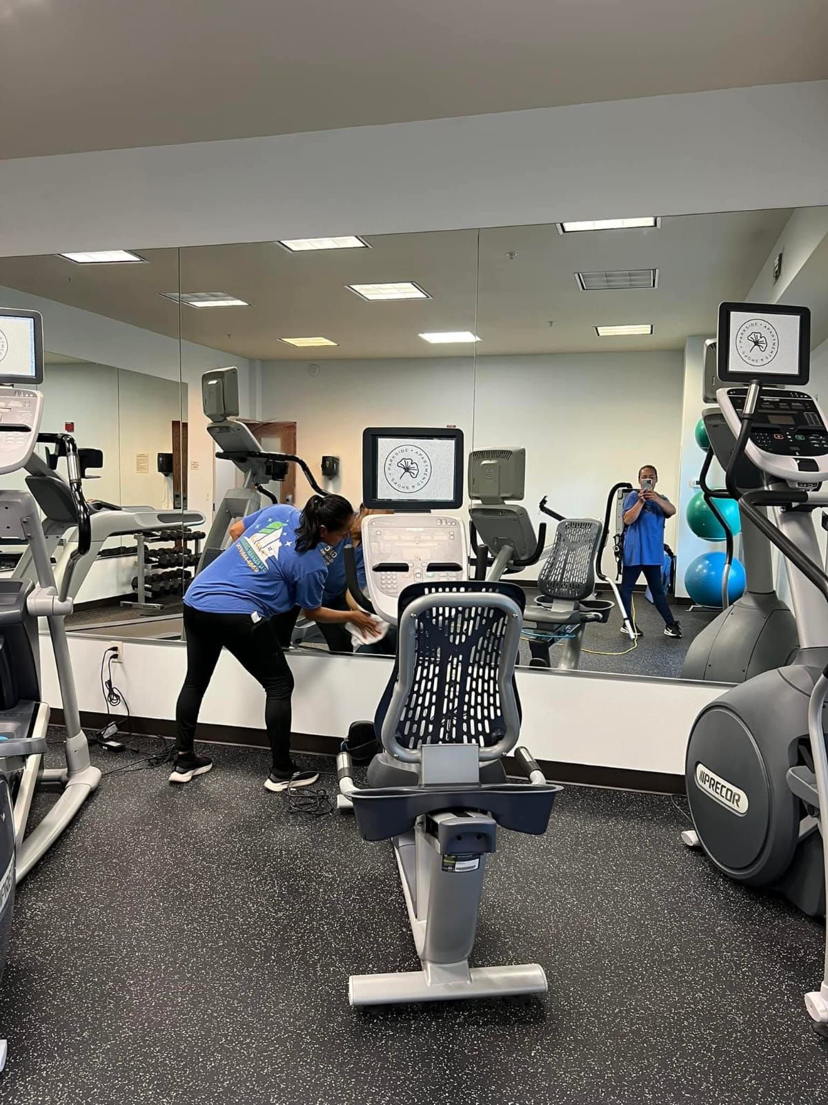 A woman is cleaning the floor of a gym.