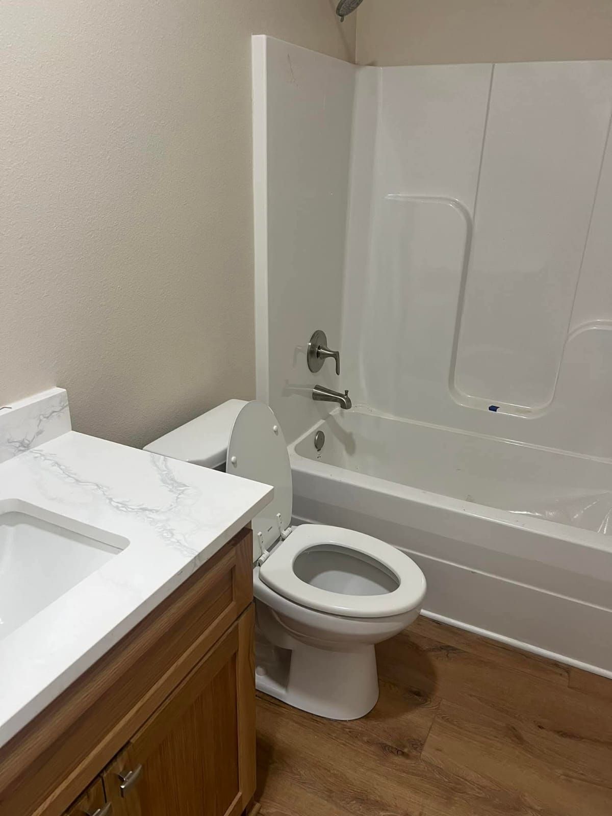 A bathroom with a toilet , sink , bathtub and shower.
