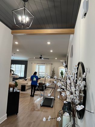 A woman is standing in a living room next to a treadmill.