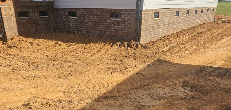 Dirt ground with brick wall of a building.