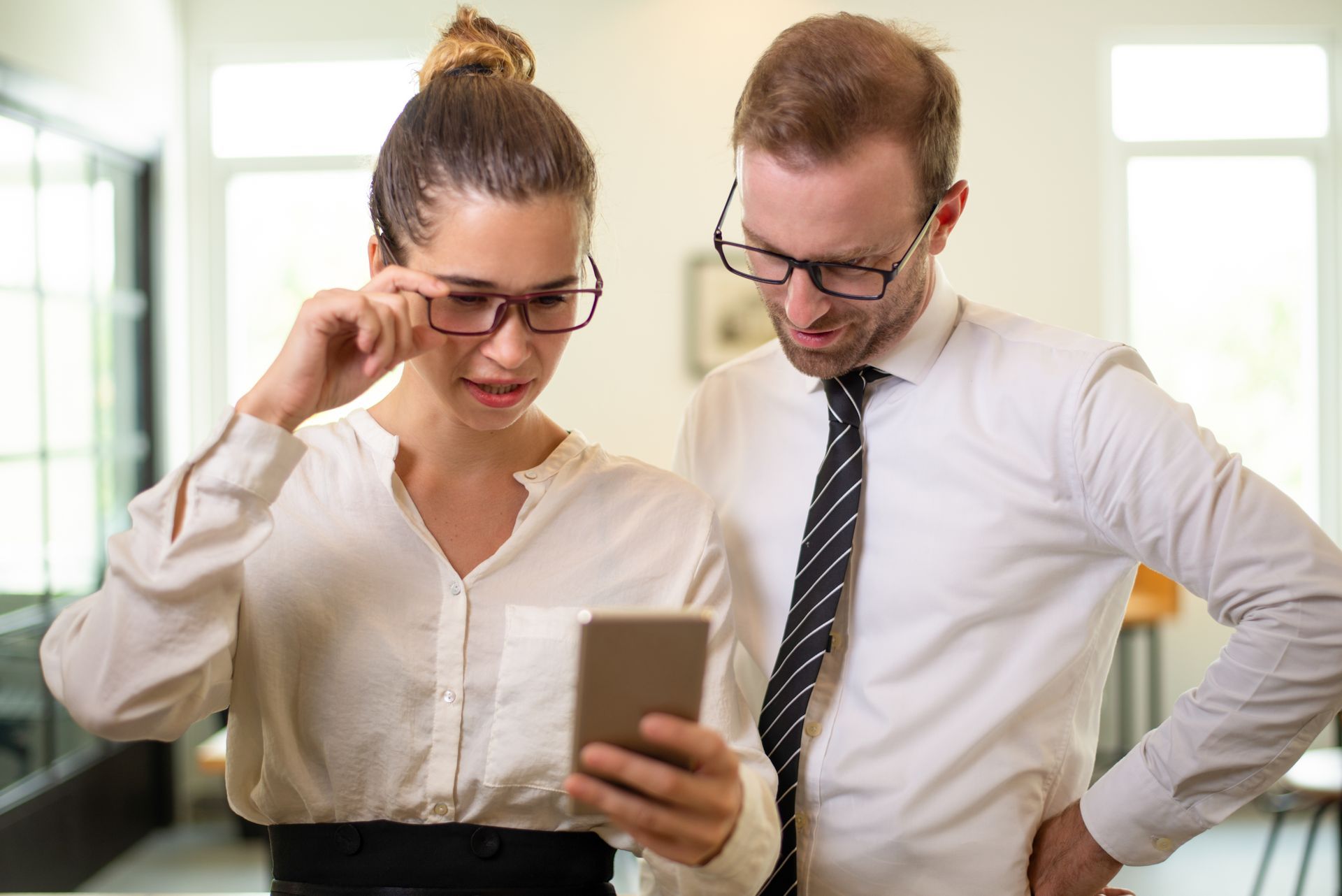 Focused business people looking at a smartphone.
